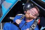 Tandem skydiver standing in the airplane door, ready to jump at Skydive California, offering the best skydiving near San Francisco.