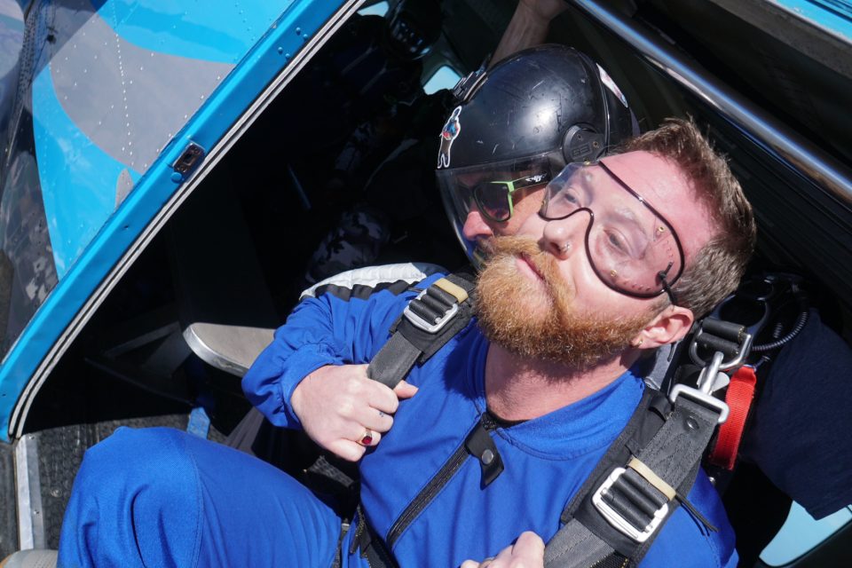 Tandem skydiver standing in the airplane door, ready to jump at Skydive California, offering the best skydiving near San Francisco.