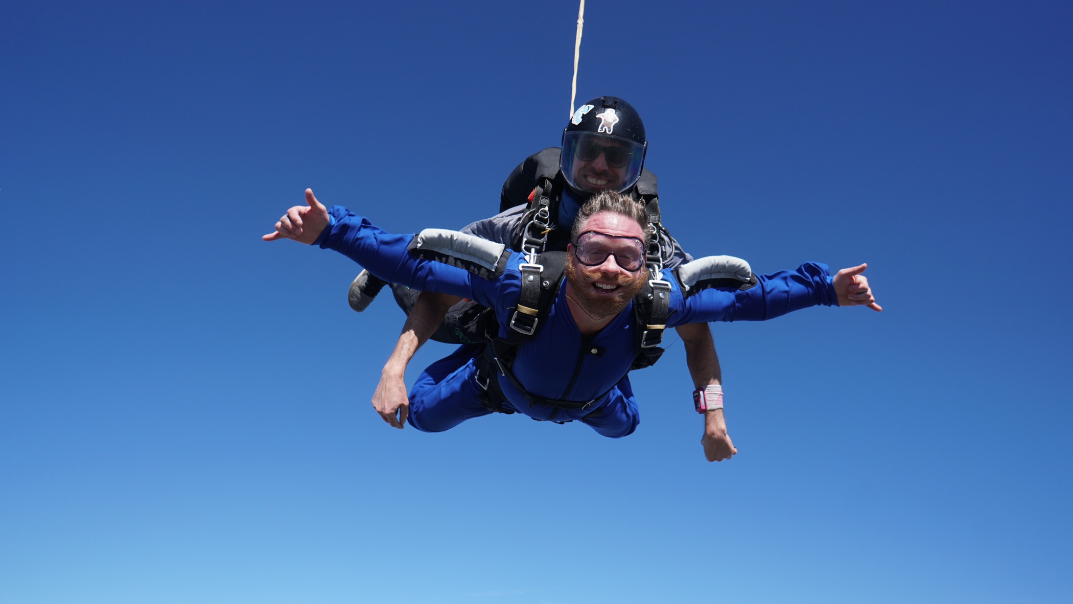 Tandem skydiver enjoying freefall with a clear blue sky at Skydive California, a popular destination for skydiving near San Francisco.