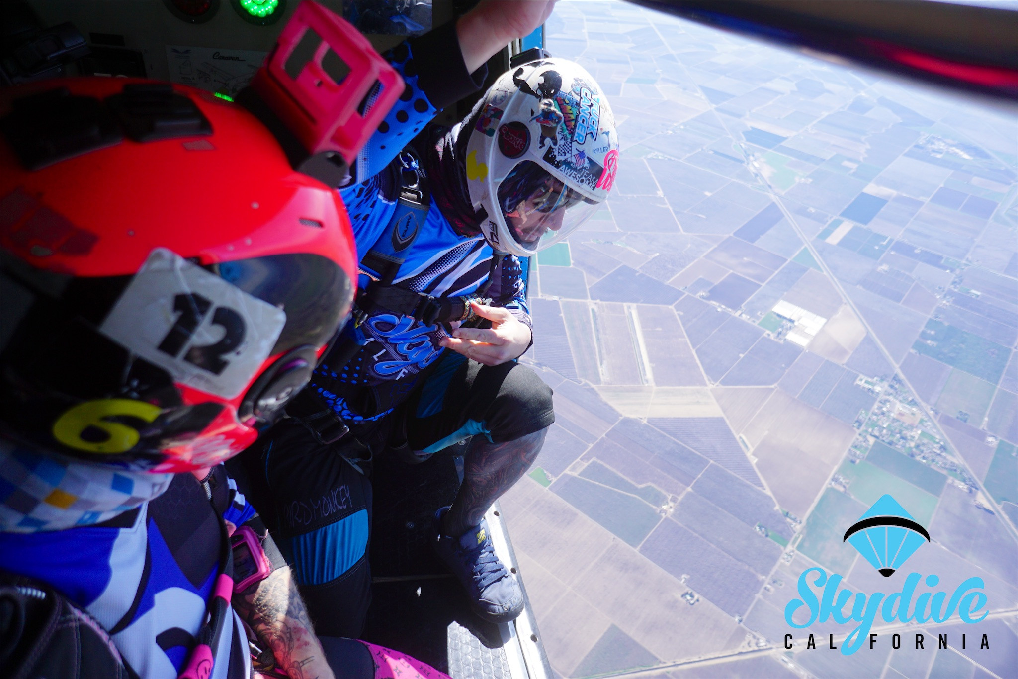 Two licensed skydivers prepare for their jump, gazing at the beautiful landscape below. Whether tandem or solo, Skydive Sacramento with Skydive California!