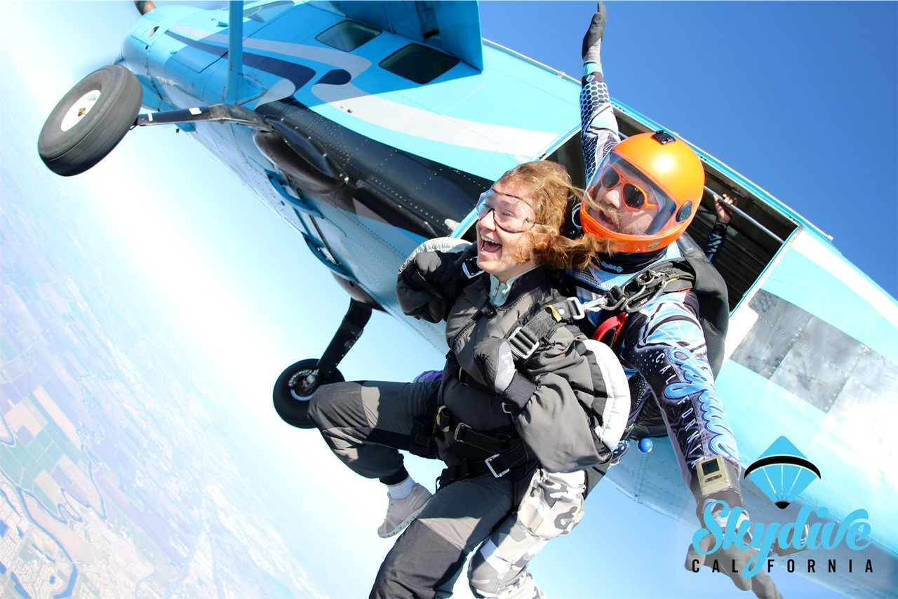 A tandem skydiver and instructor leap from an aircraft at 13,000 feet, beginning an exhilarating freefall over the San Francisco Bay Area.