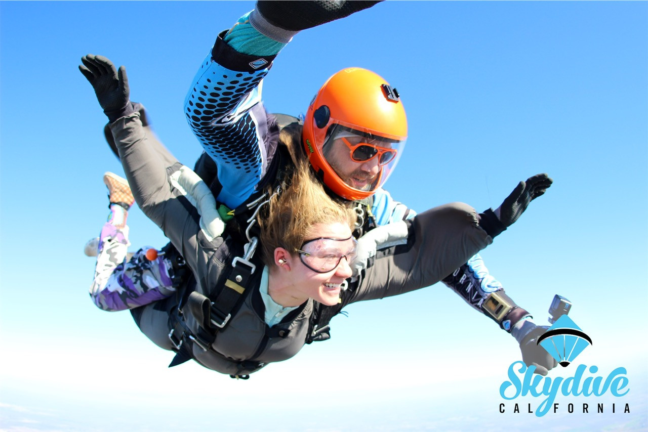  A first-time tandem skydiver smiles with excitement as they freefall at 120 mph with their instructor high above the San Joaquin River.