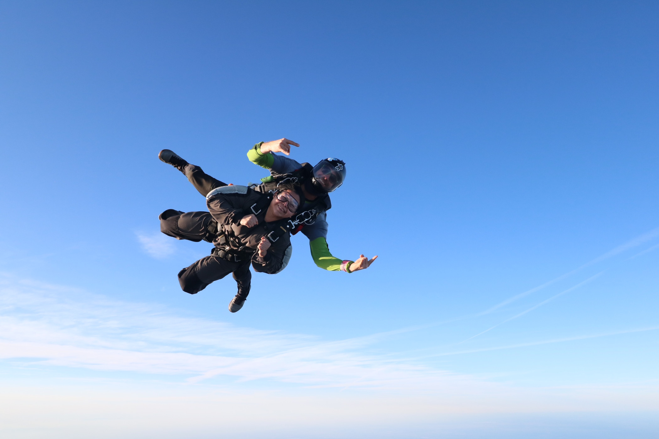 Exciting tandem skydiving in San Francisco area—Instructor and passenger smiling during freefall.