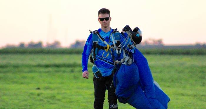 experienced skydiver walking with canopy after skydive.