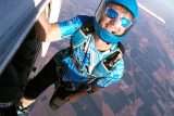 Experienced skydiver hanging off of Skydive California air craft