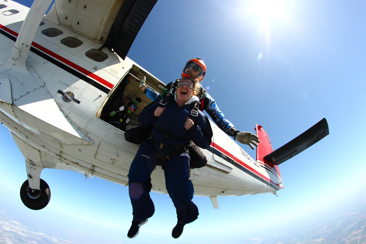 Female tandem jumper leaps from Skydive California air craft.