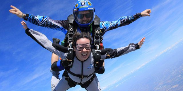 Tandem skydiver smiling from the excitement of free fall