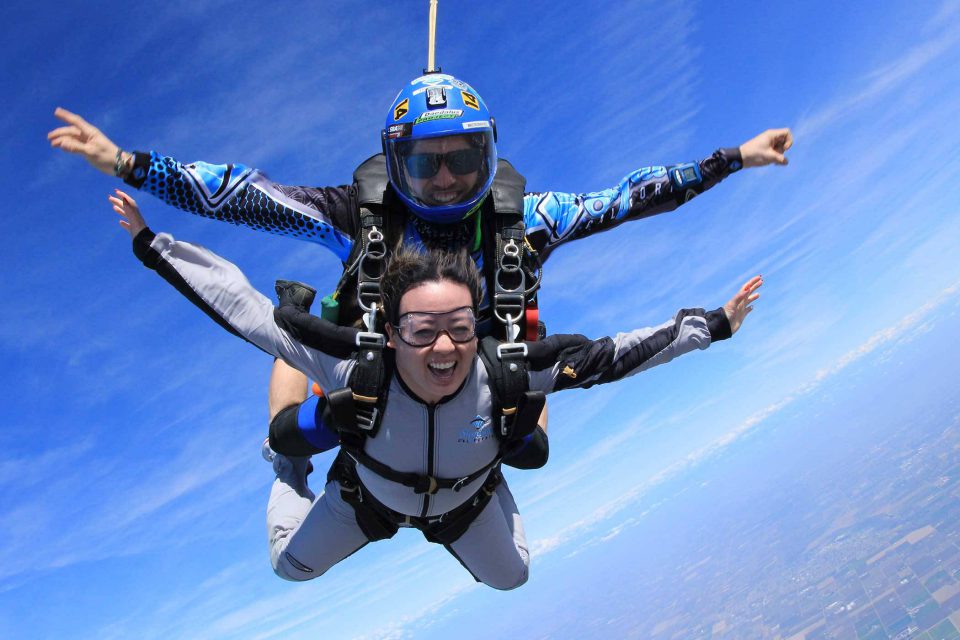 Tandem skydiver smiling from the excitement of free fall
