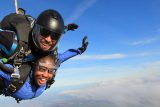 Female tandem jumper enjoying free fall with Skydive Cal instructor