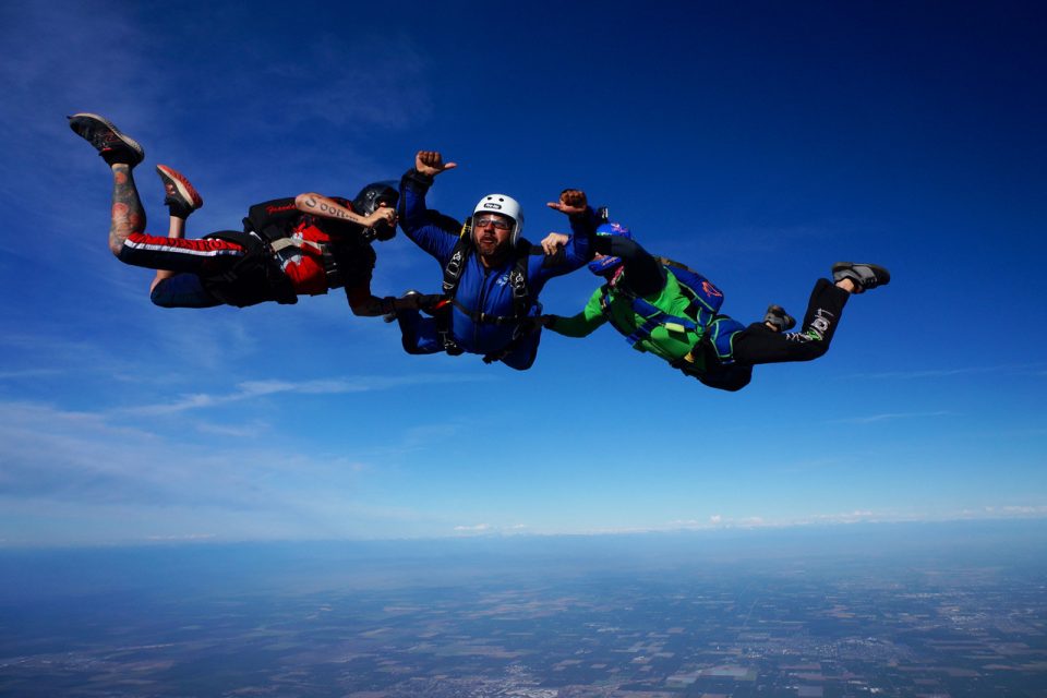 Skydive California student in free fall with two instructors.