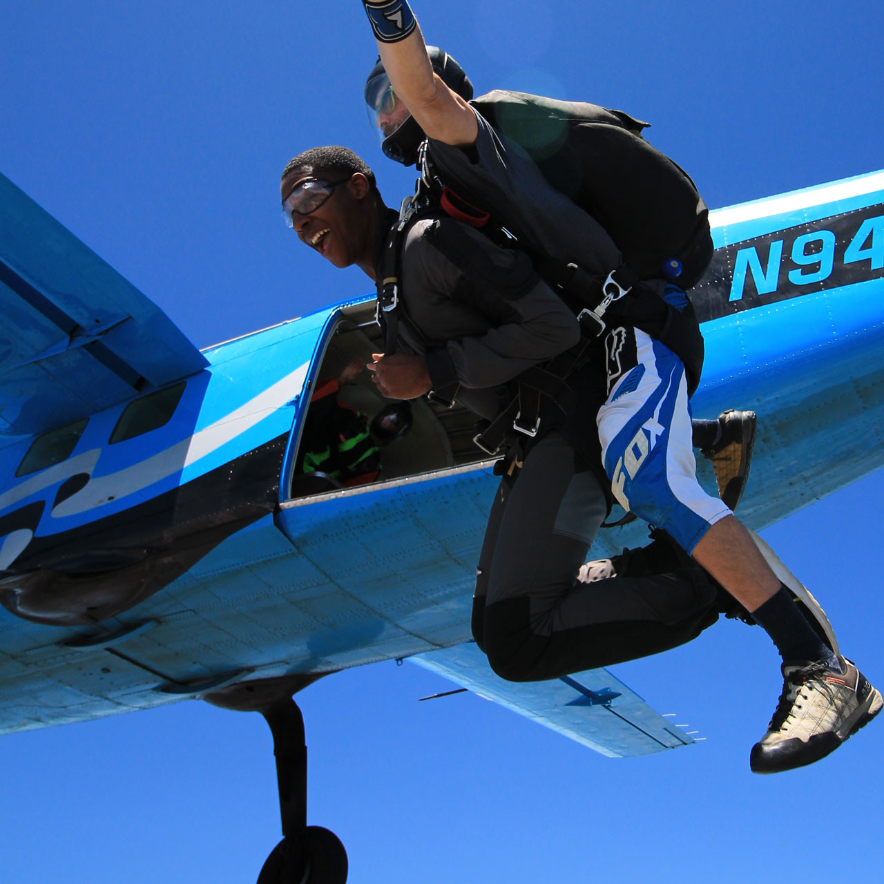 Male tandem skydiver leaping from Skydive California air craft.